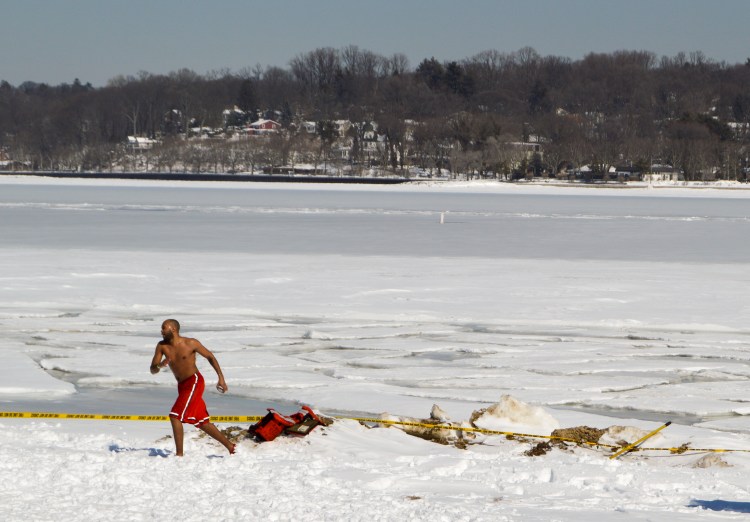 A man runs along the frozen ocean to join fellow Polar Plunge volunteers.
